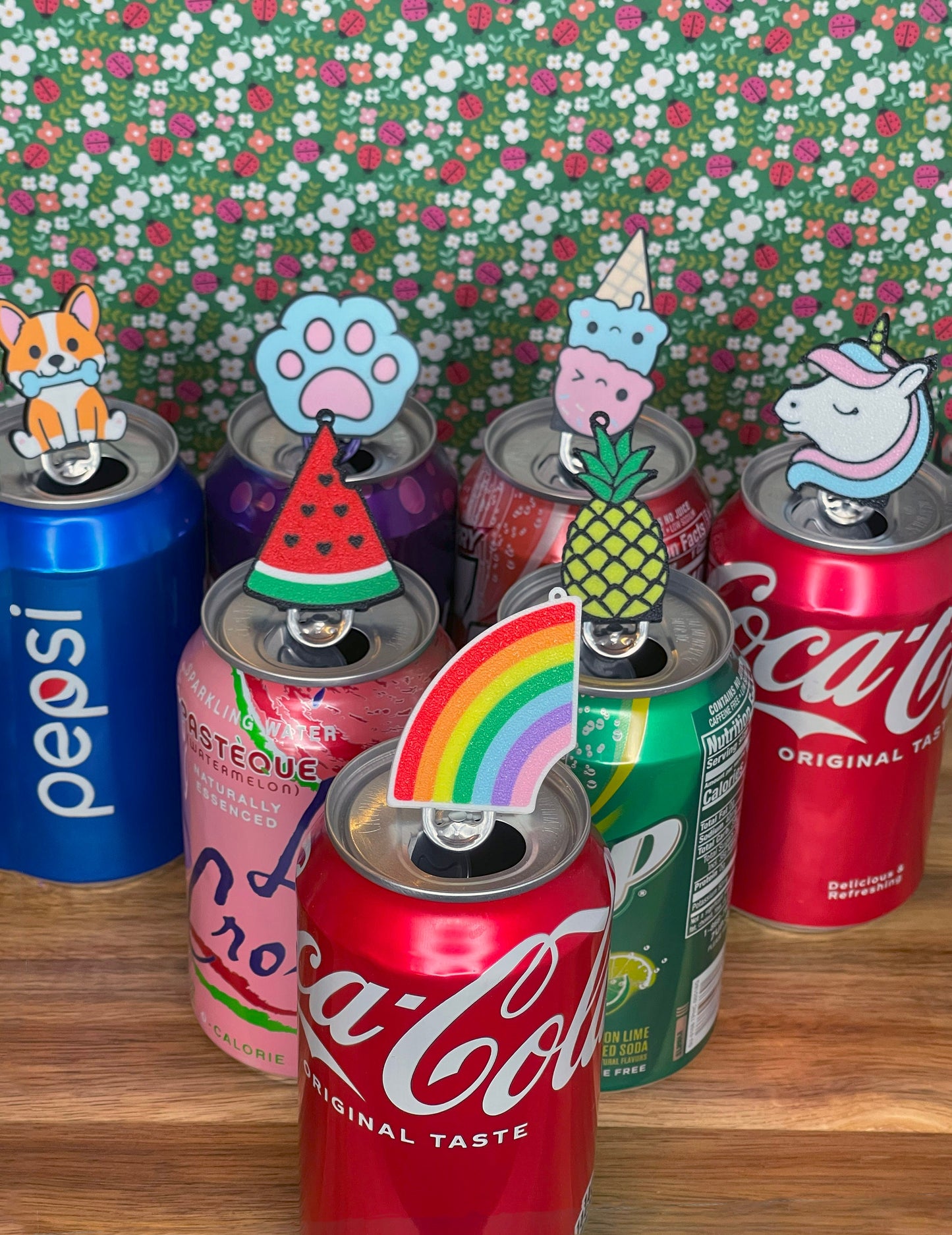 Collection of soda cans with Tab Buddies on a floral background
