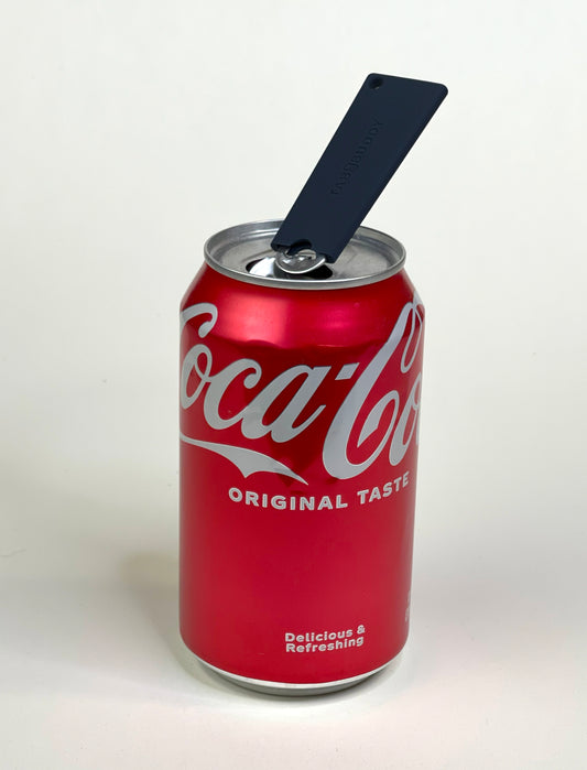 A black Tab Buddy Classic rests atop the tab of a red can of soda after opening it.