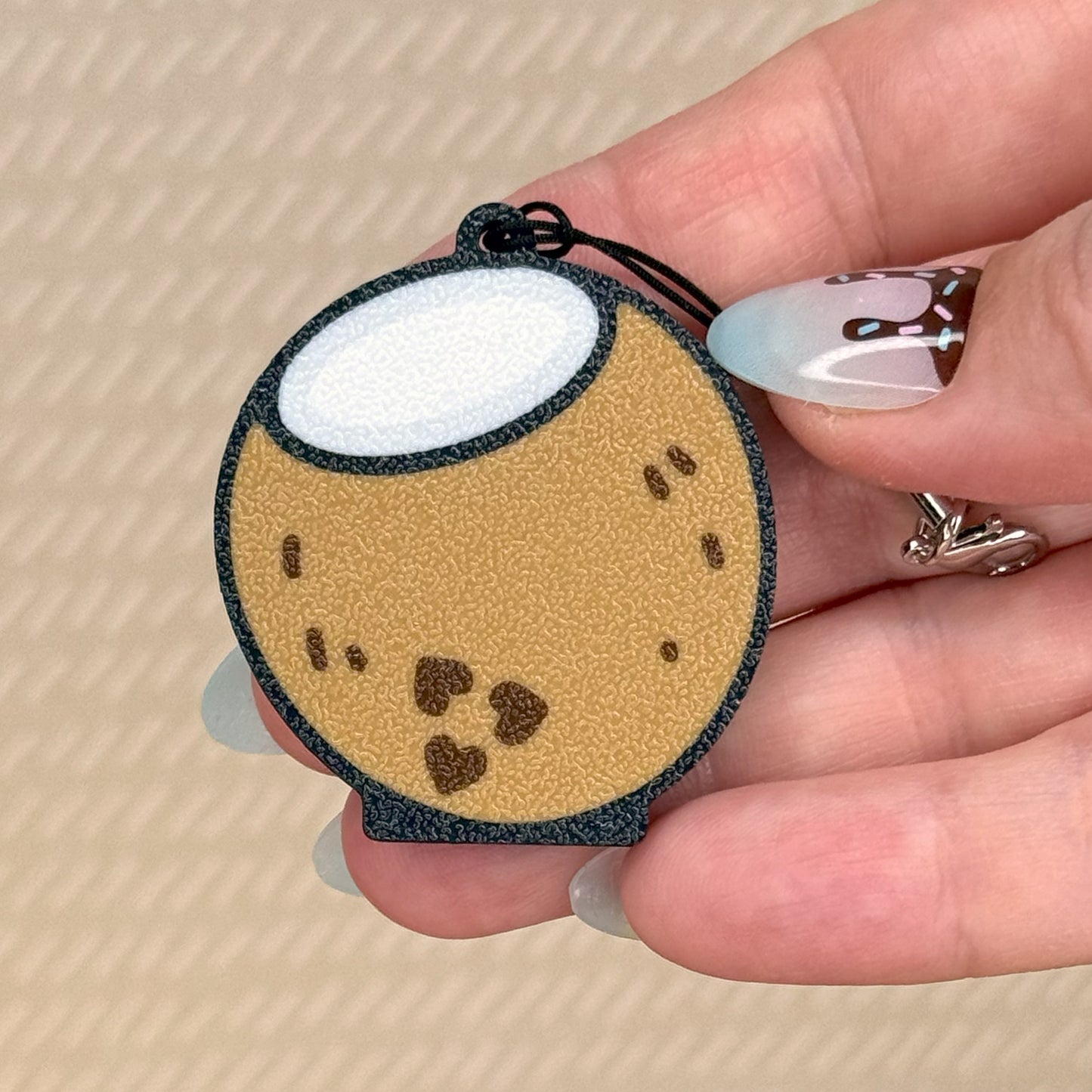 Hand holding a coconut Tab Buddy with on a beige background