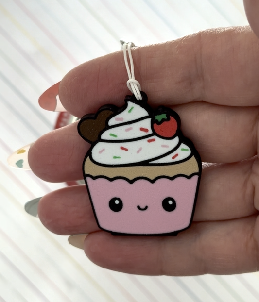Cute cupcake-shaped Tab Buddy held in a hand on a light background