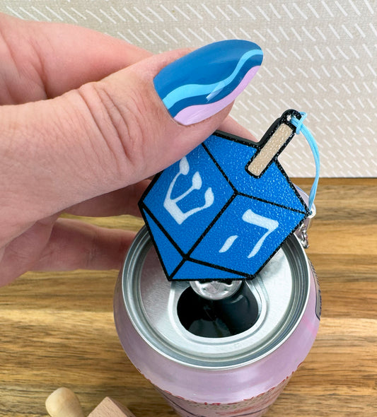 Blue dreidel Tab Buddy on a can on a wooden surface