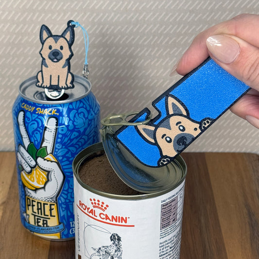 A matching set of German Shepherd-inspired Tab Buddies are shown. The soda-sized Tab Buddy rests atop a blue soda can, and the Tab Buddy XL is used to peel back a can of dog food.