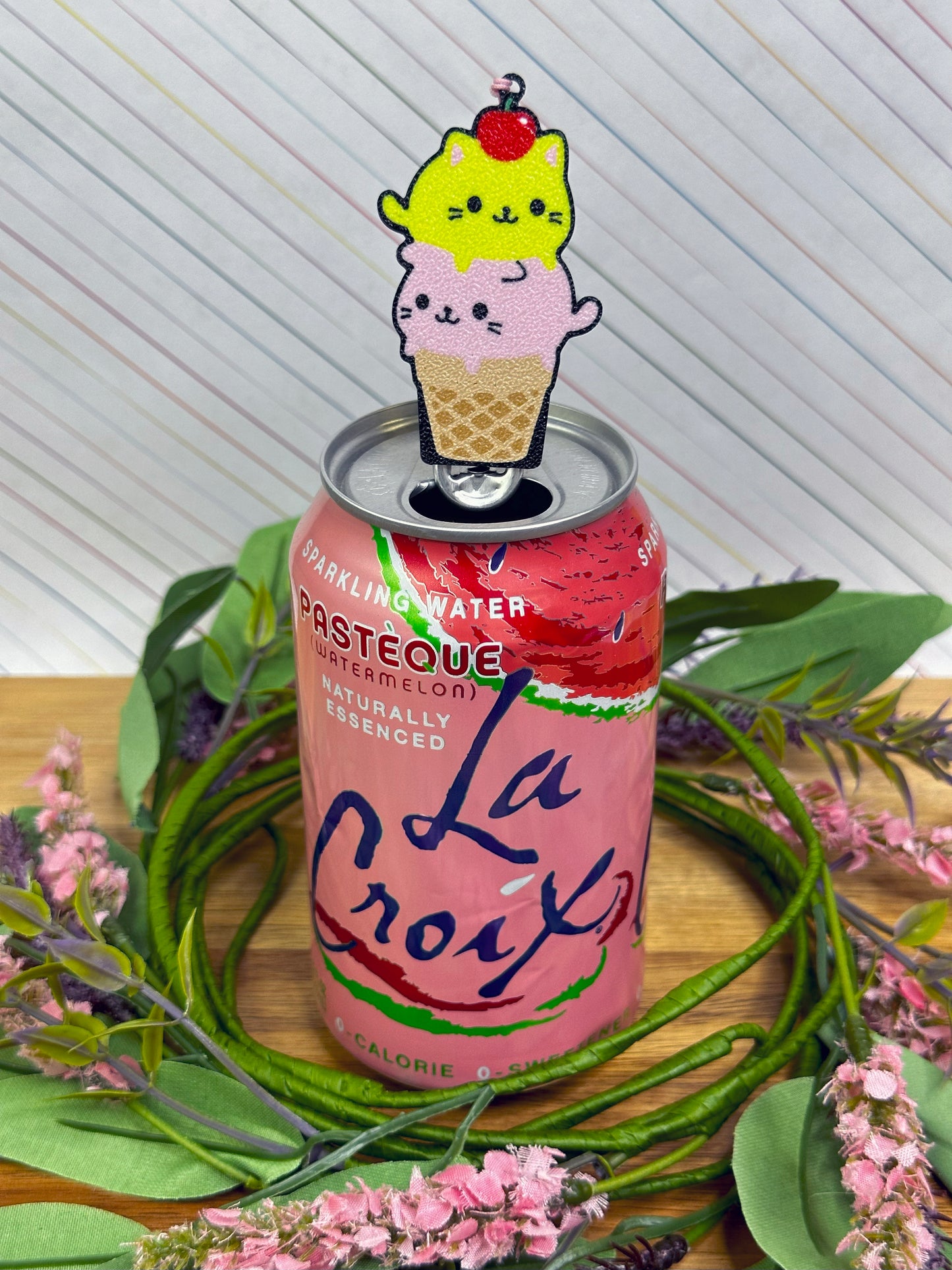 La Croix sparkling water can with a cute kitty-themed ice cream cone Tab Buddy on top, surrounded by greenery and flowers.
