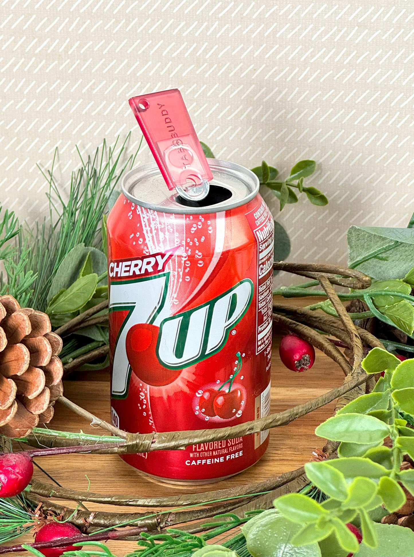 7-up cherry can with a red translucent Tab Buddy Mini on a decorative background with greenery