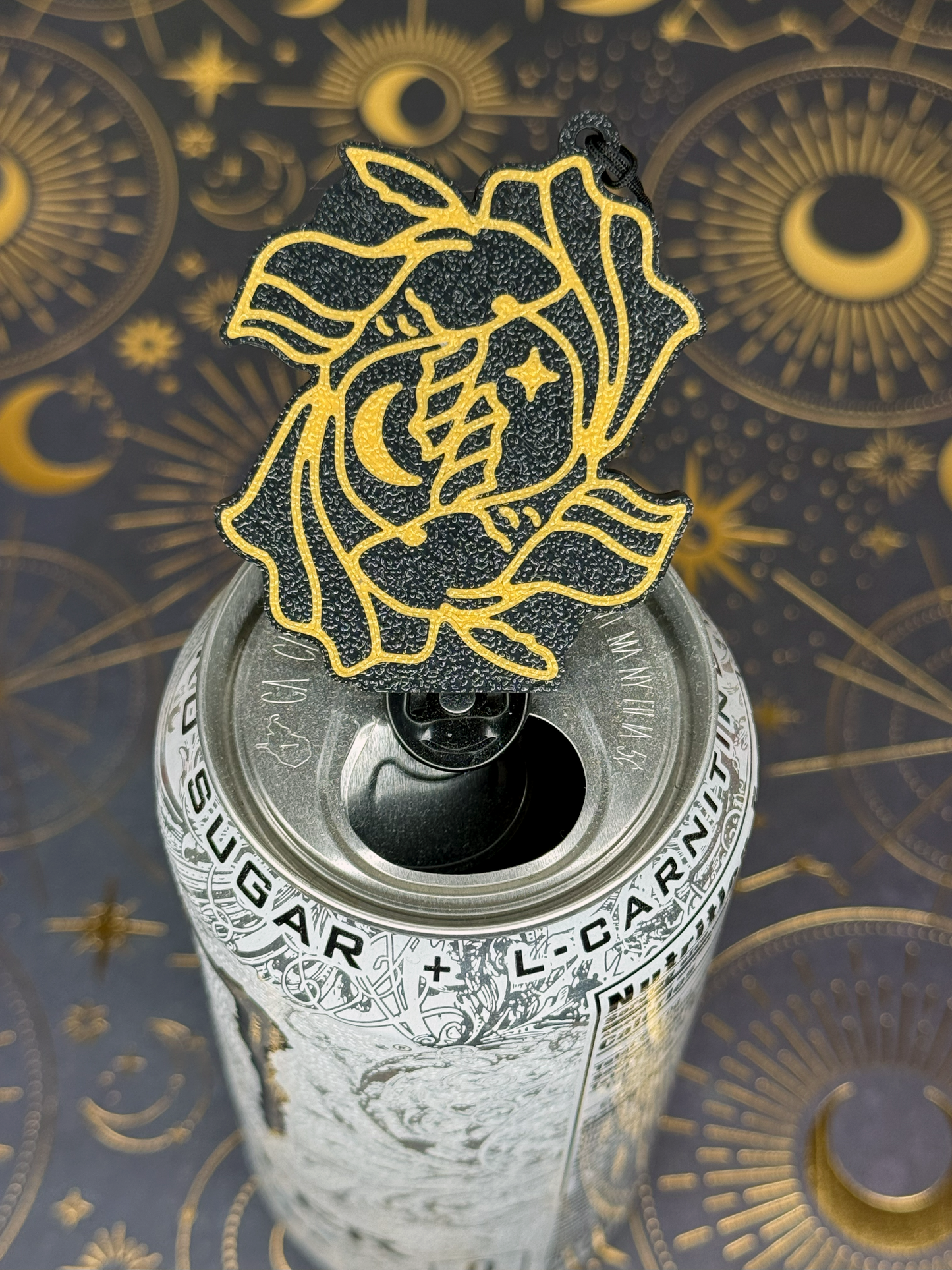 Decorative black and gold Pisces Tab Buddy keychain design sits atop a can tab on a mystical background