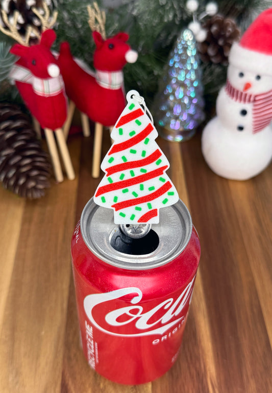 Can with a Christmas tree-shaped Tab Buddy on a wooden surface with festive decorations.