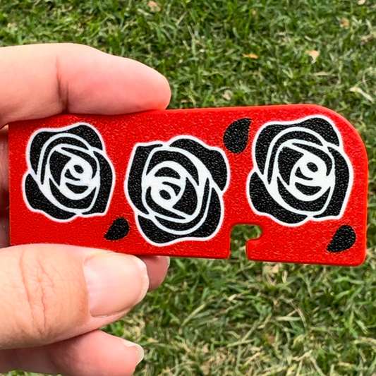 Red Tab Buddy XL with black rose designs held by a hand on grass