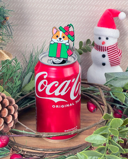 Soda can with a Christmas-themed Tab Buddy featuring a dog holding a gift, surrounded by festive decorations.