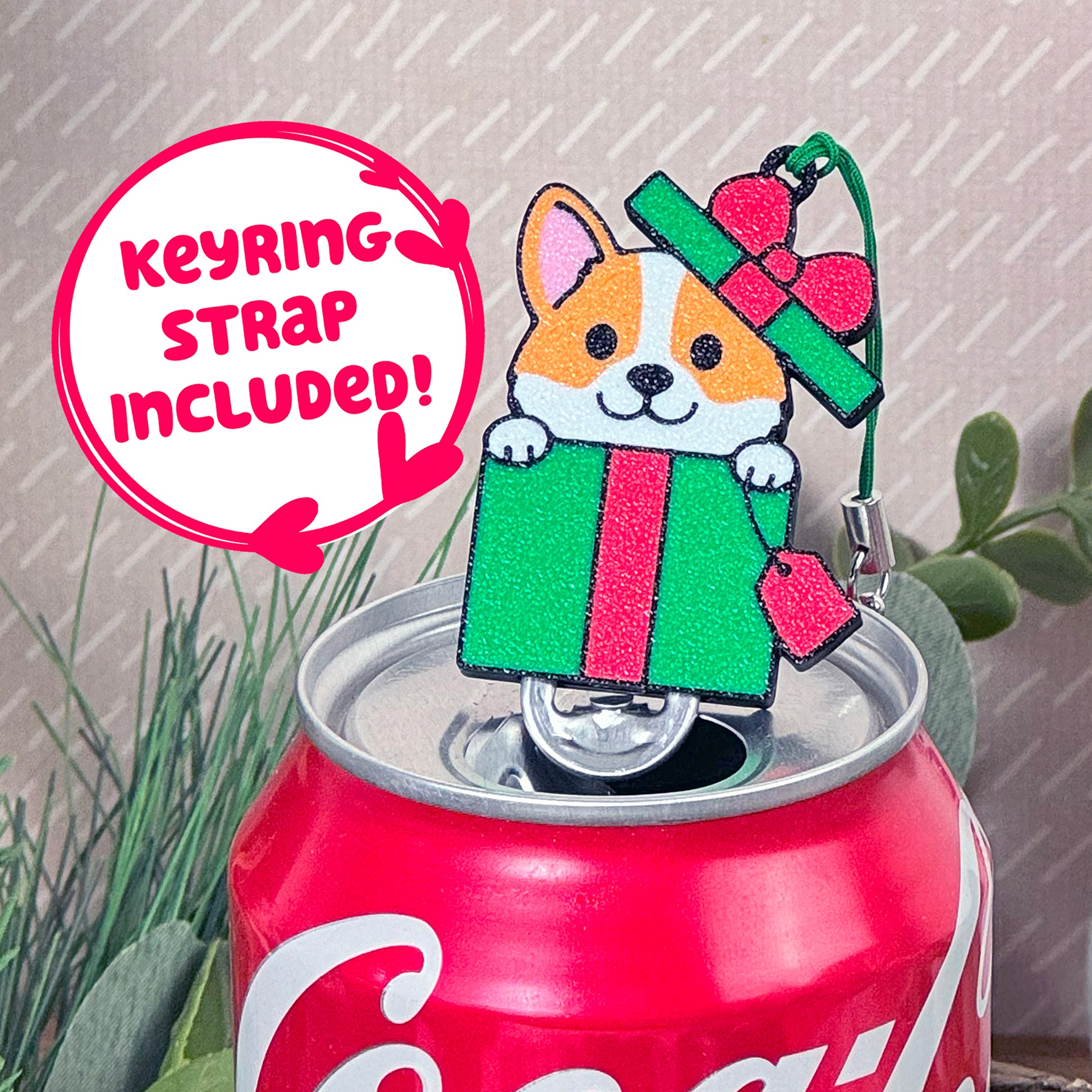 Tab Buddy with a dog design on top of a Coca-Cola can with textg that reads 'keyring strap included!'