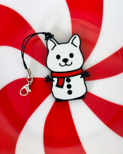 Snowman dog-shaped Tab Buddy keychain with a red scarf on a peppermint candy background