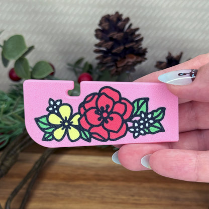 Pink Tab Buddy XL floral designs held by a hand, with a natural background