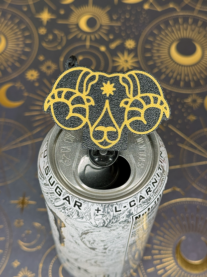 Can of energy drink with a ram's head Aries Tab Buddy design on top against a celestial pattern background