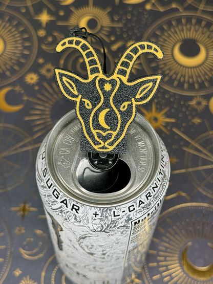 Can with a Capricorn goat head Tab Buddy on top against an astrological symbol background