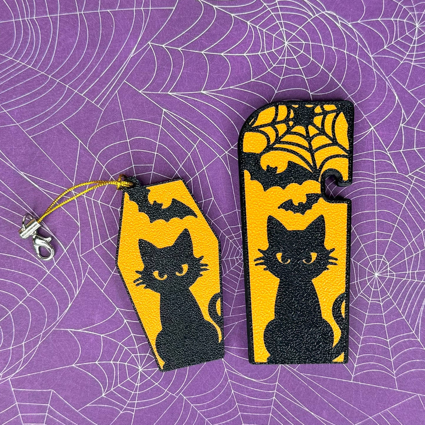 A matching set of Halloween-themed soda and XL Tab Buddies with black cat and bats design on a purple spiderweb background