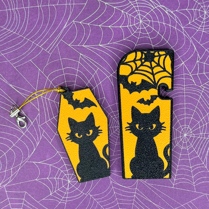 A matching set of Halloween-themed soda and XL Tab Buddies with black cat and bats design on a purple spiderweb background
