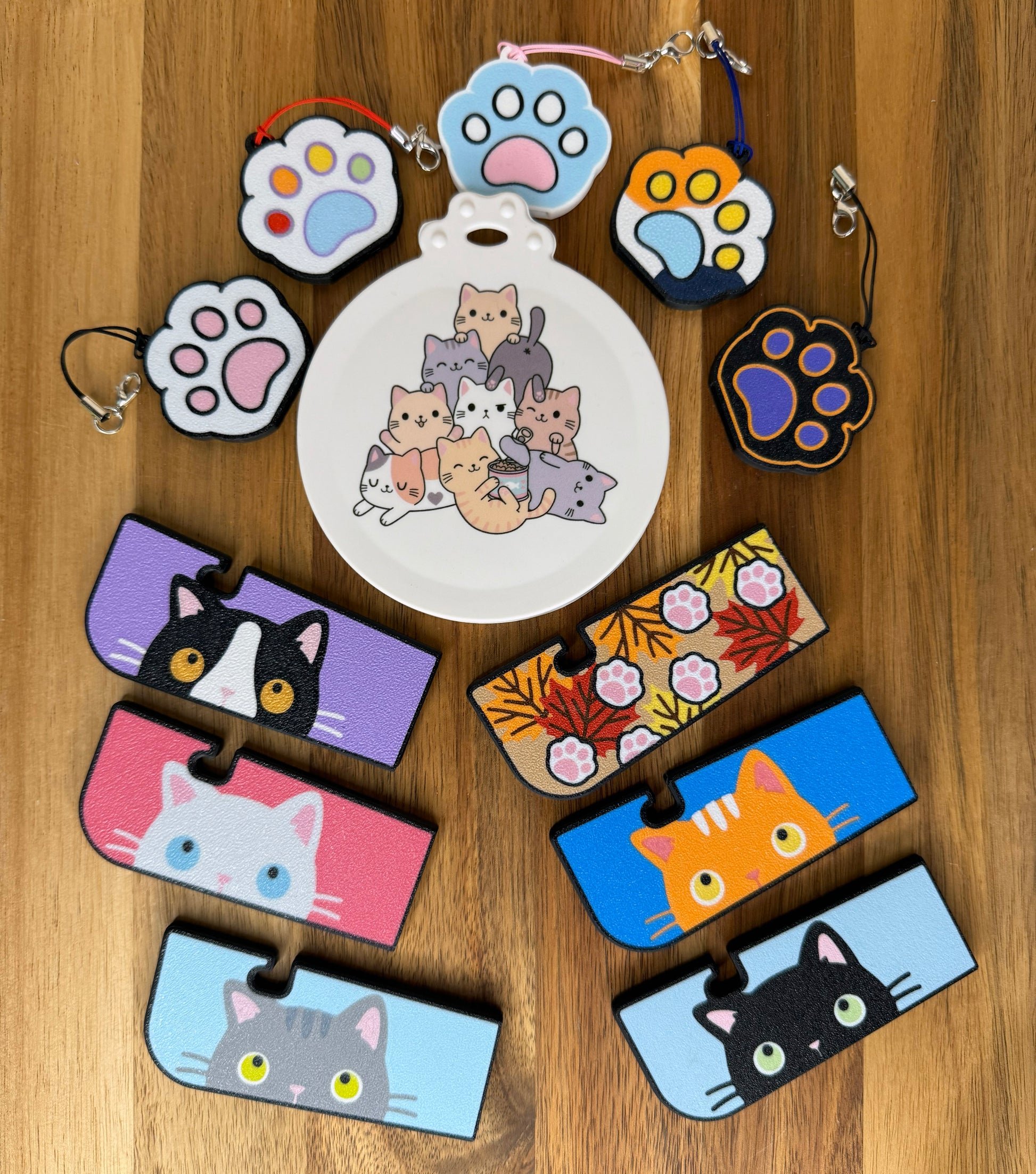 Collection of cat-themed Tab Buddy products and paw-shaped keychains on a wooden surface.