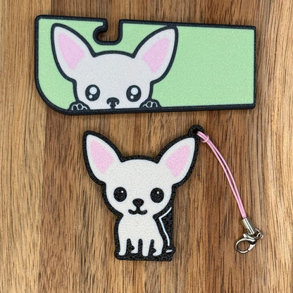 A matching set of Chihuahua-inspired soda Tab Buddy and Tab Buddy XL rest atop a wooden surface.