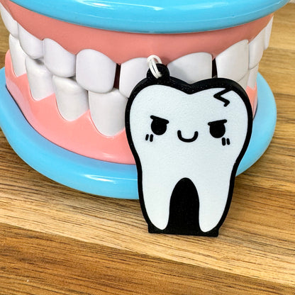 Cartoon tooth Tab Buddy in front of a model of teeth on a wooden surface