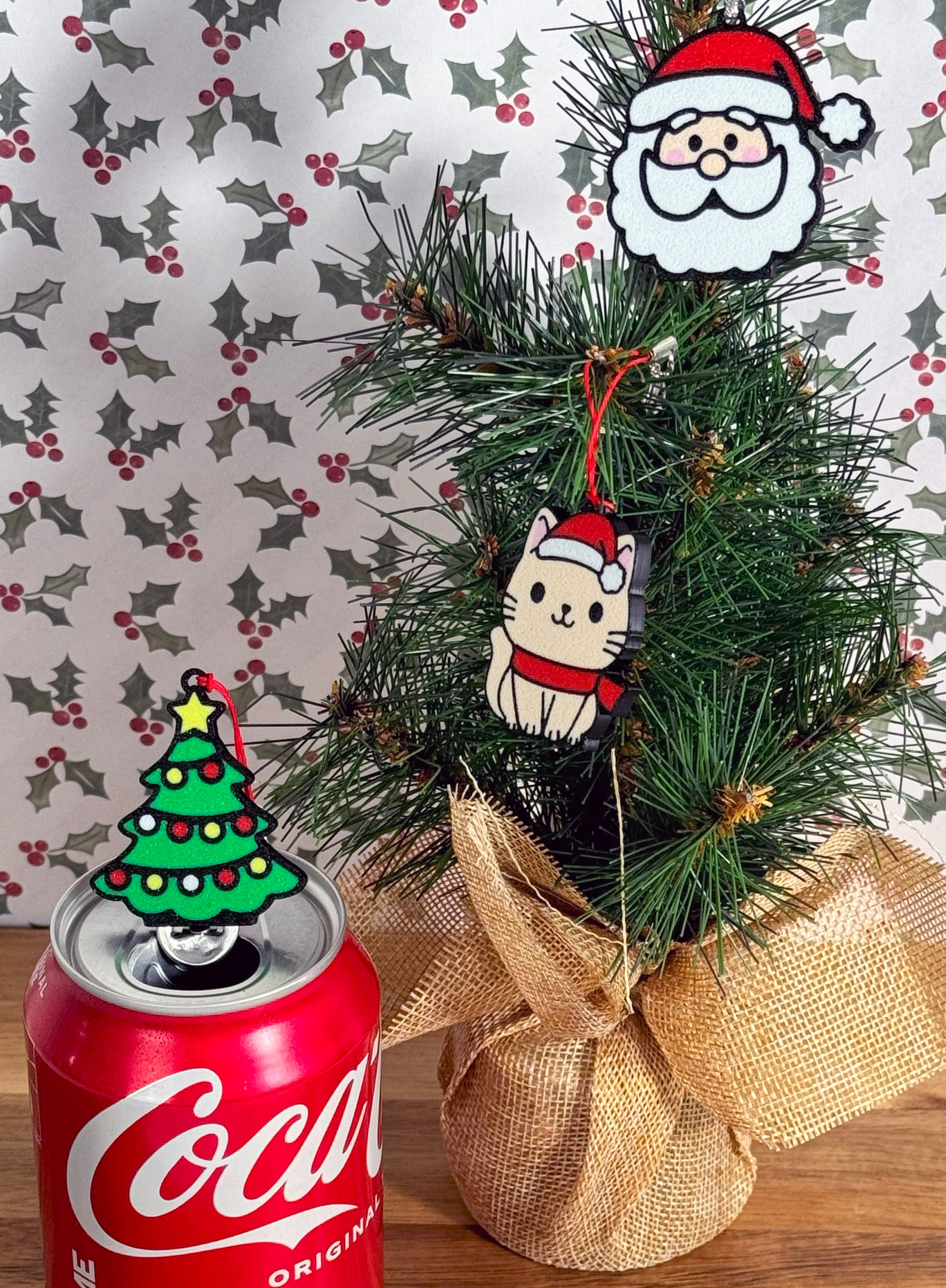Decorative Christmas tree with Coca-Cola can and christmas themed Tab Buddies on a patterned background