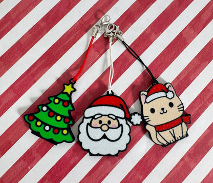 Three Christmas-themed Tab Buddies on a red and white striped background