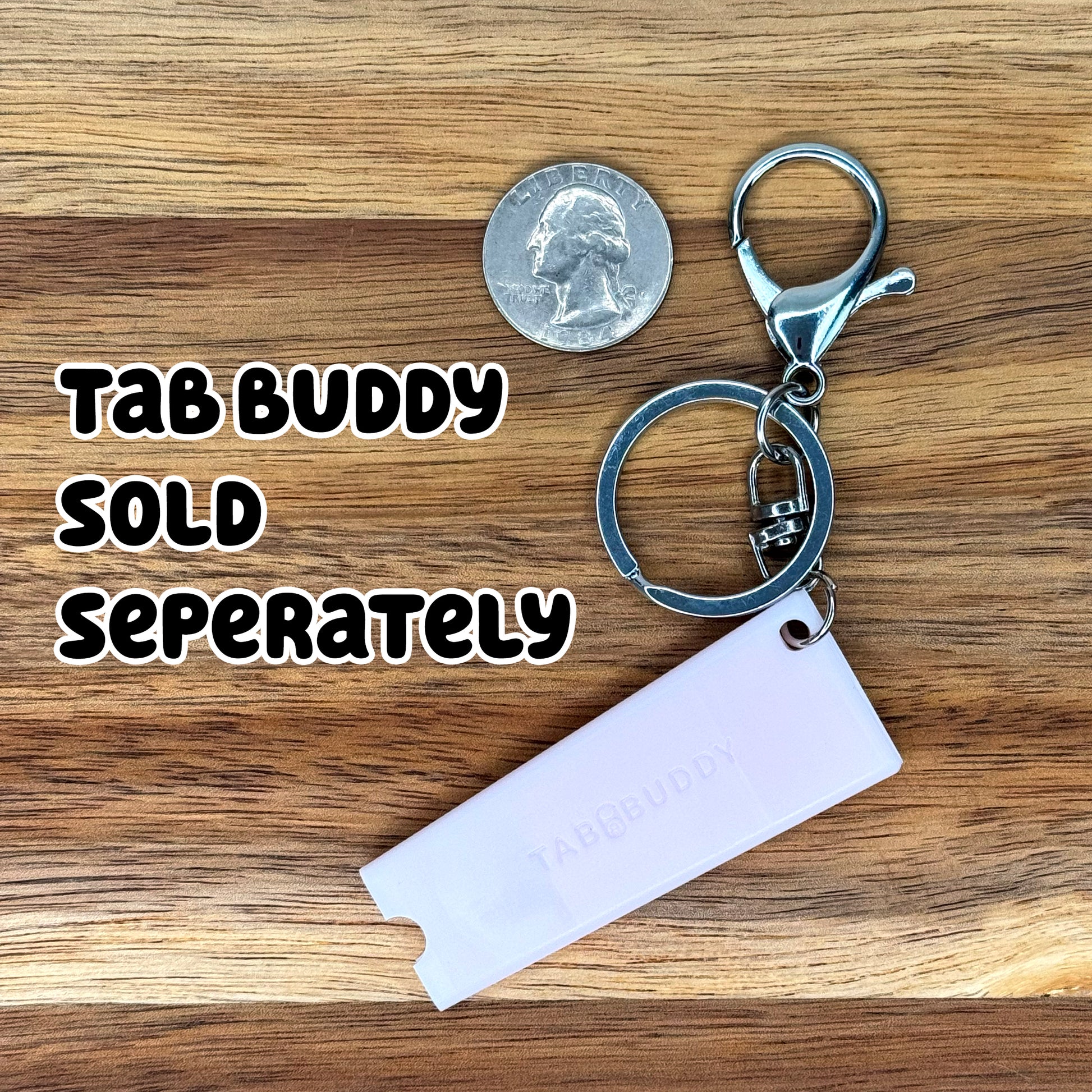 Tab Buddy Classic is shown with add-on keychain attached on a wooden surface, text 'Tab Buddy Sold Separately' displayed.
