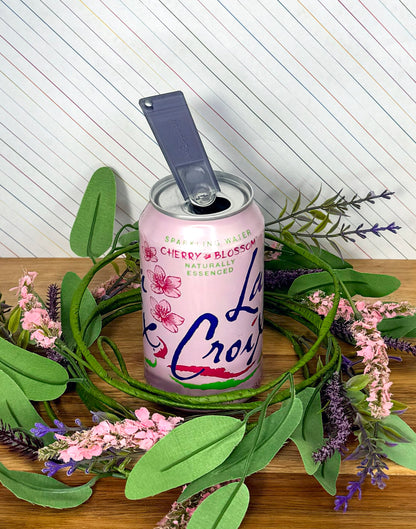 LaCroix cherry blossom sparkling water can with a translucent Onyx Tab Buddy Classic with background of decorative wreath, flowers and leaves.