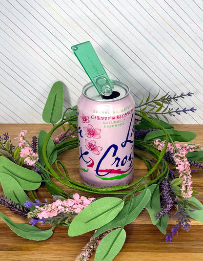 Lacrosse cherry blossom can with an Emerald green translucent Tab Buddy Classic on a decorative wreath of flowers and leaves.
