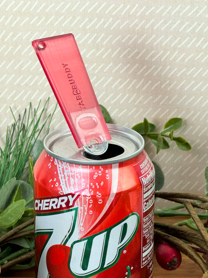 7-Up cherry can with a translucent ruby red Tab Buddy Classic opener on a neutral background