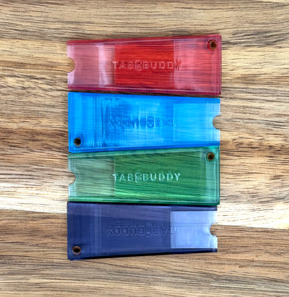 Colorful transluscent Tab Buddy Classics rest on a wooden surface
