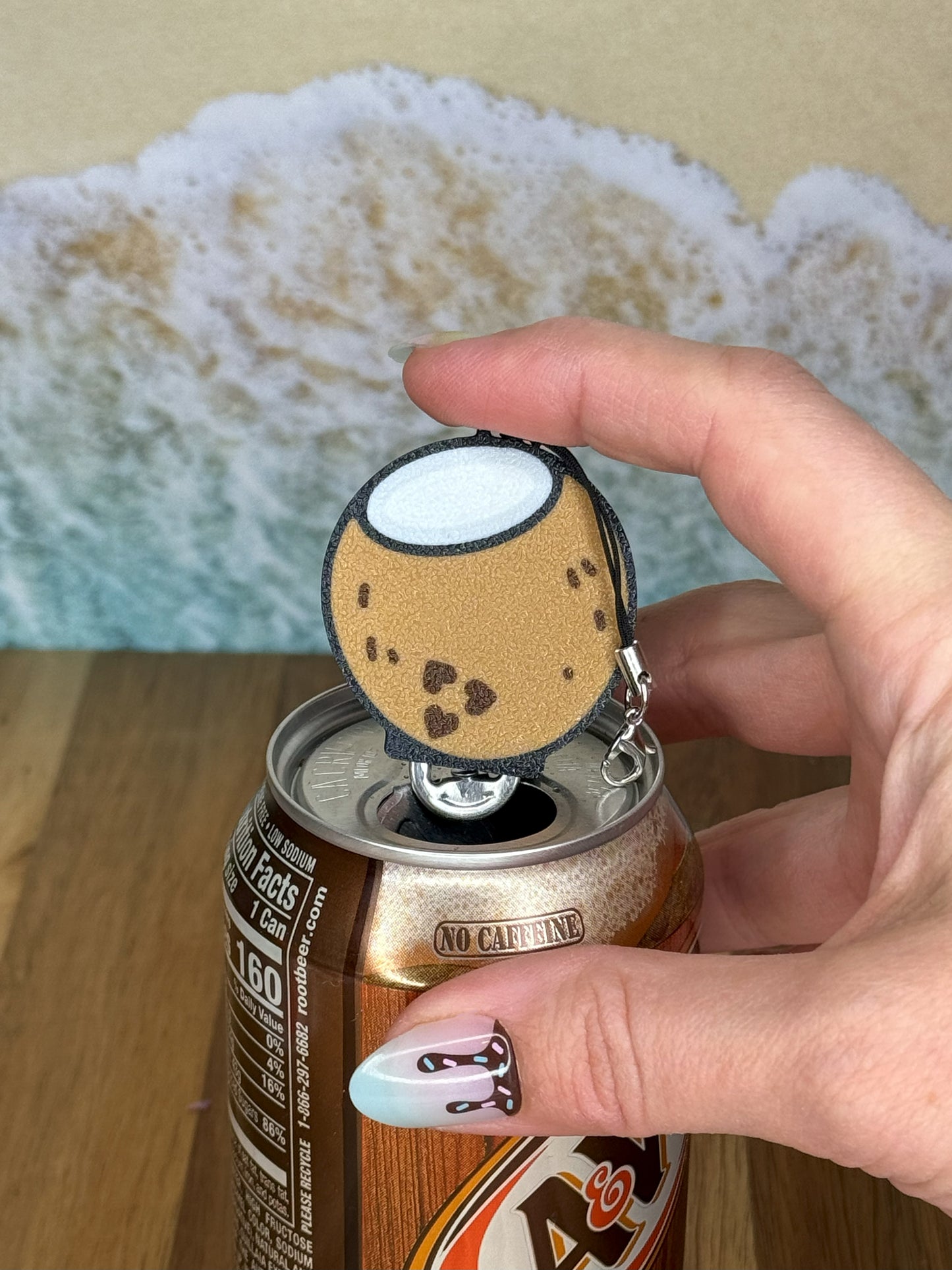 Hand holding a coconut Tab Buddy on top of a can.