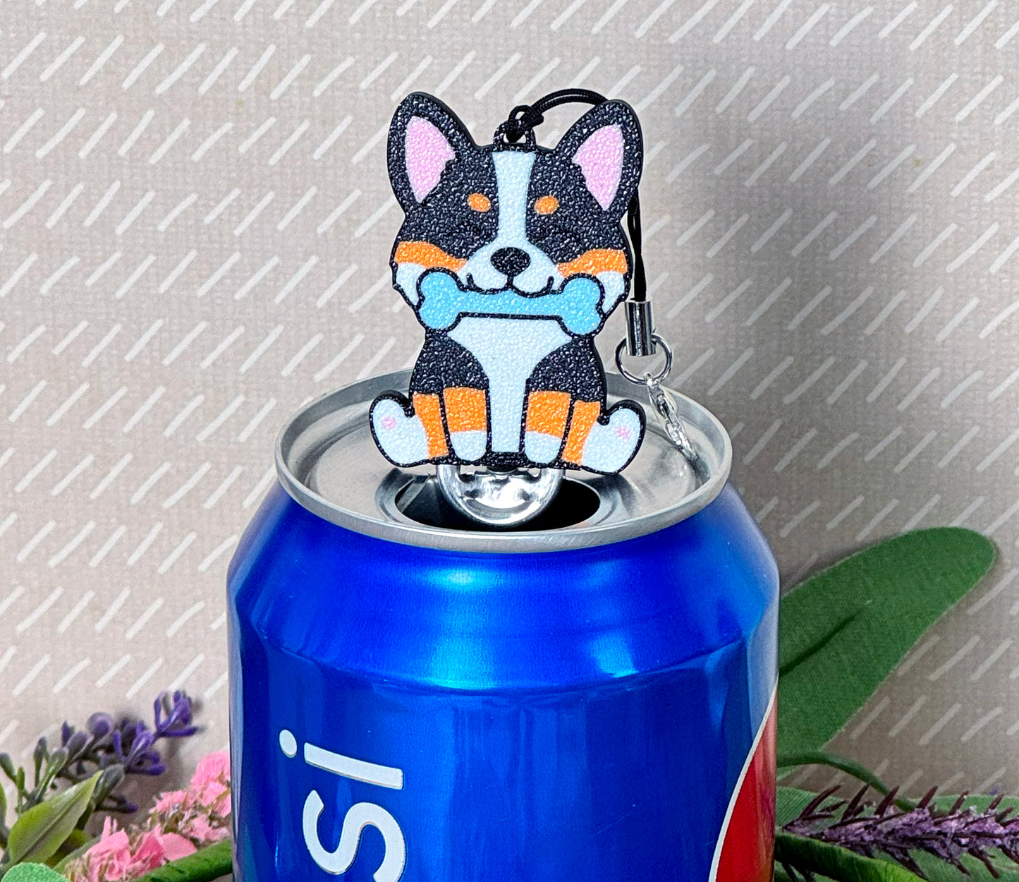 Tab Buddy shaped like a corgi with a blue bone on a soda can against a gray background.