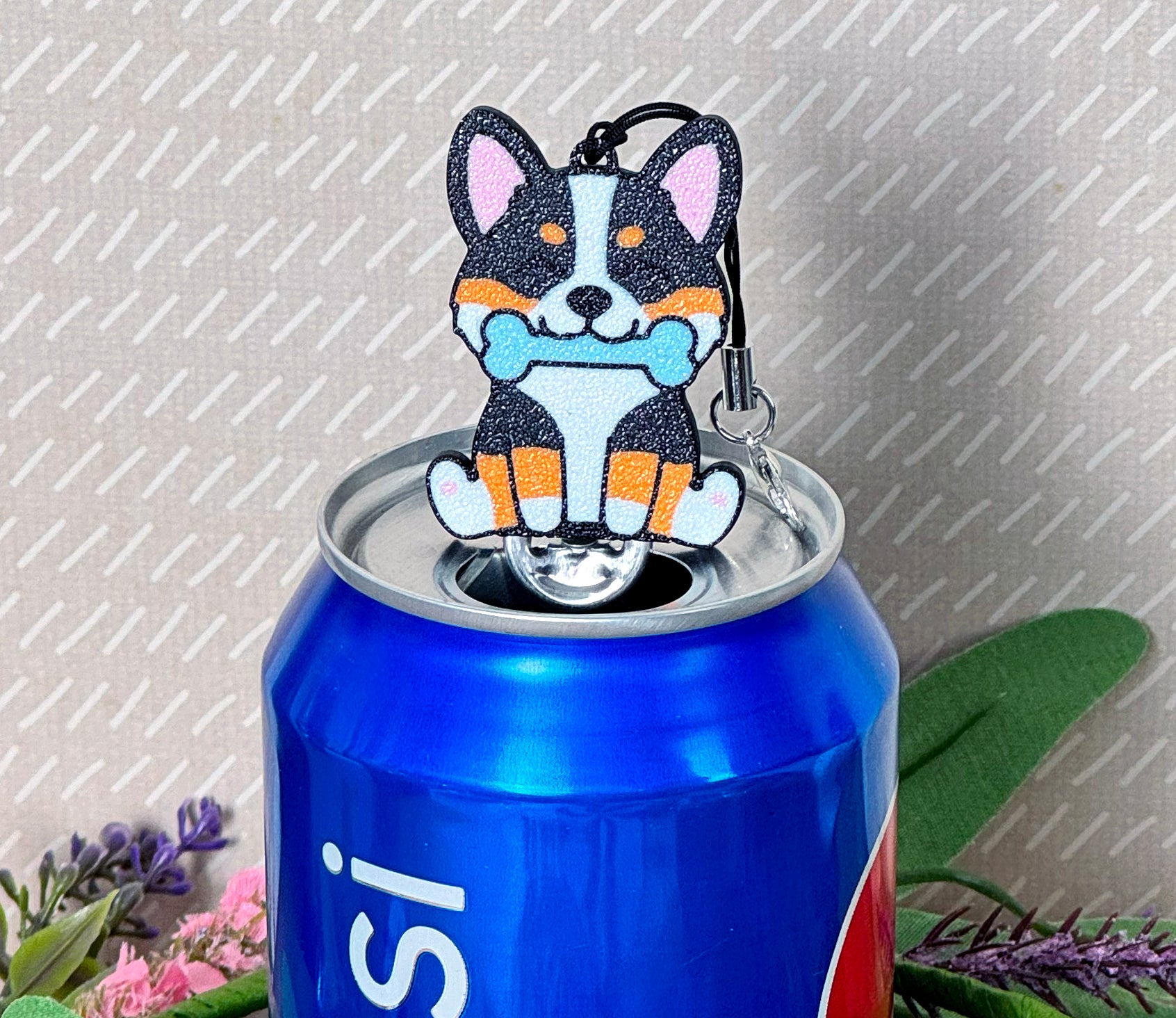 Tab Buddy shaped like a corgi with a blue bone on a soda can against a gray background.