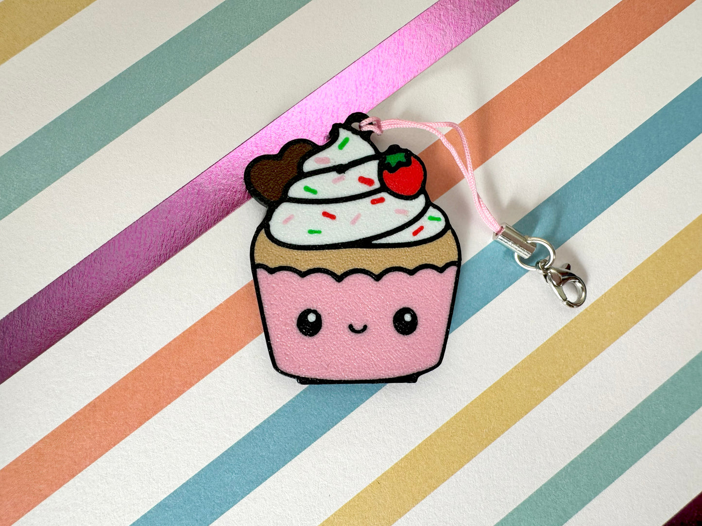 Cute cupcake-shaped Tab Buddy with a cherry on top against a striped background