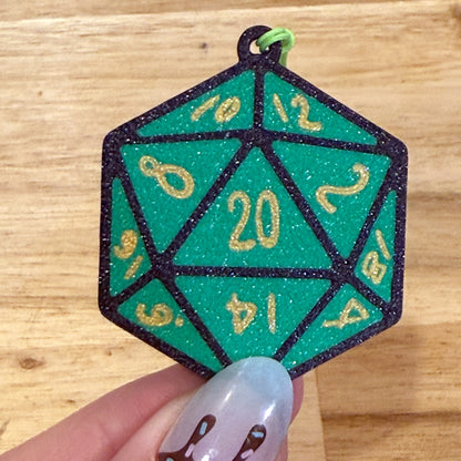 Green D20 dice Tab Buddy held by a hand on a wooden surface