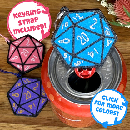 A blue D20 dice Tab Buddy sits atop a red drink can with pink and purple D20 Tab Buddies in background. Text indicates "keyring strap included"