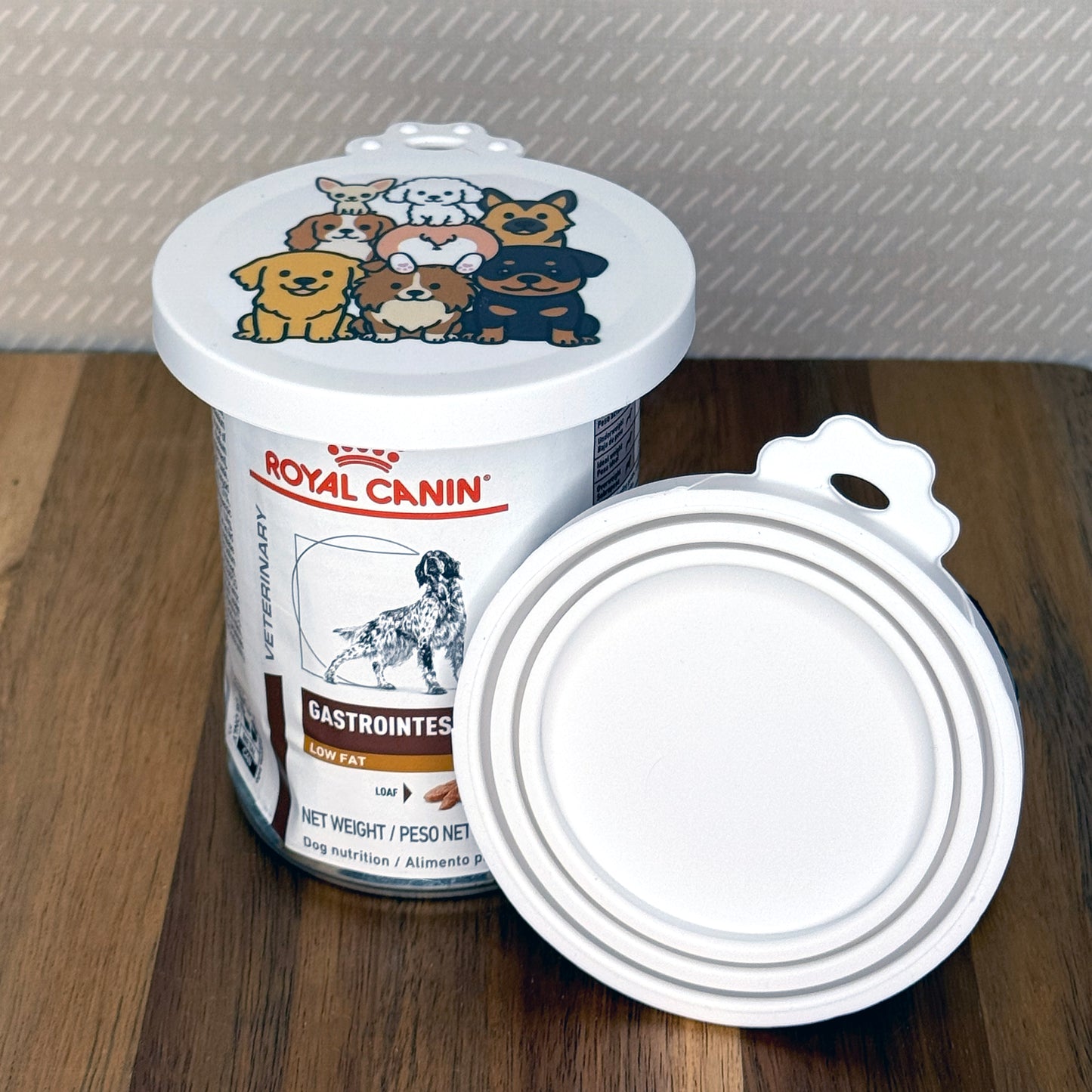 A can of dog food is sealed with a resusable silicone can cover. An additional lid is shown facing outward with multiple circular rings that stretch to seal various sized cans.