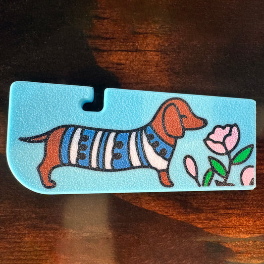 Tab Buddy XL with a dachshund wearing a sweater and flowers on a wooden surface