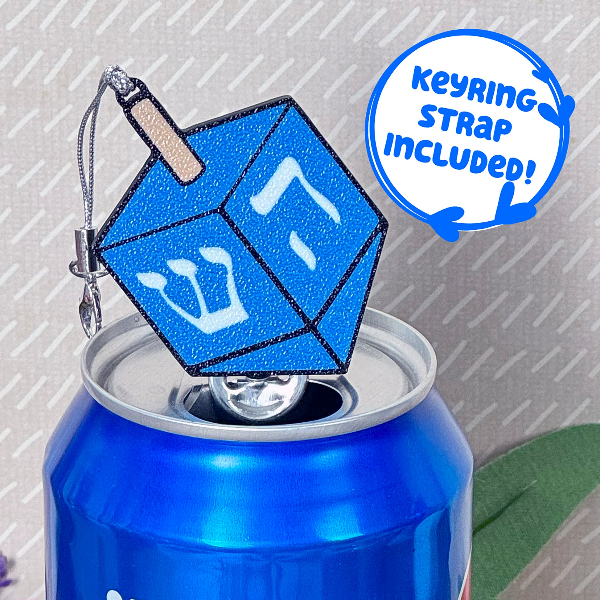 Blue glittery dreidel Tab Buddy on a can with 'Keyring strap included!' text.