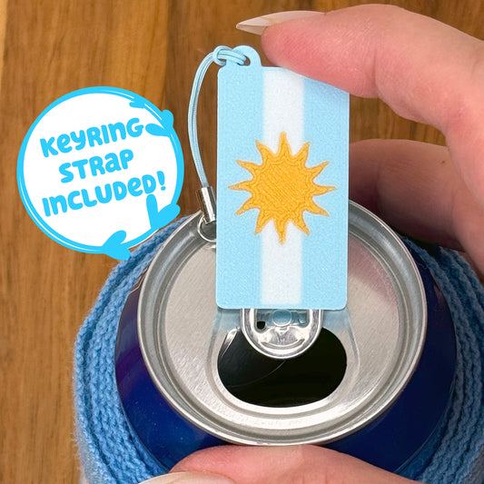 Tab Buddy with Argentina flag design sits atop a soda can, held by a hand.