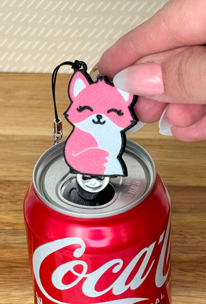 Pink fox-shaped Tab Buddy keychain sits atop a Coca-Cola can