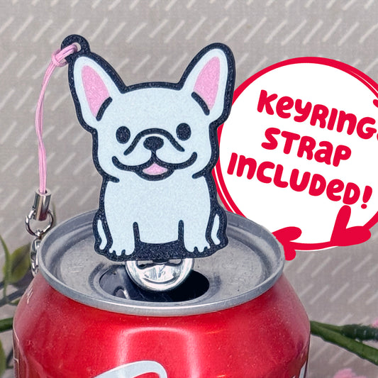 A Ahite French Bulldog-inspired Tab Buddy rests atop an open can tab. Desecriptive text reads "Keyring Strap Included!"