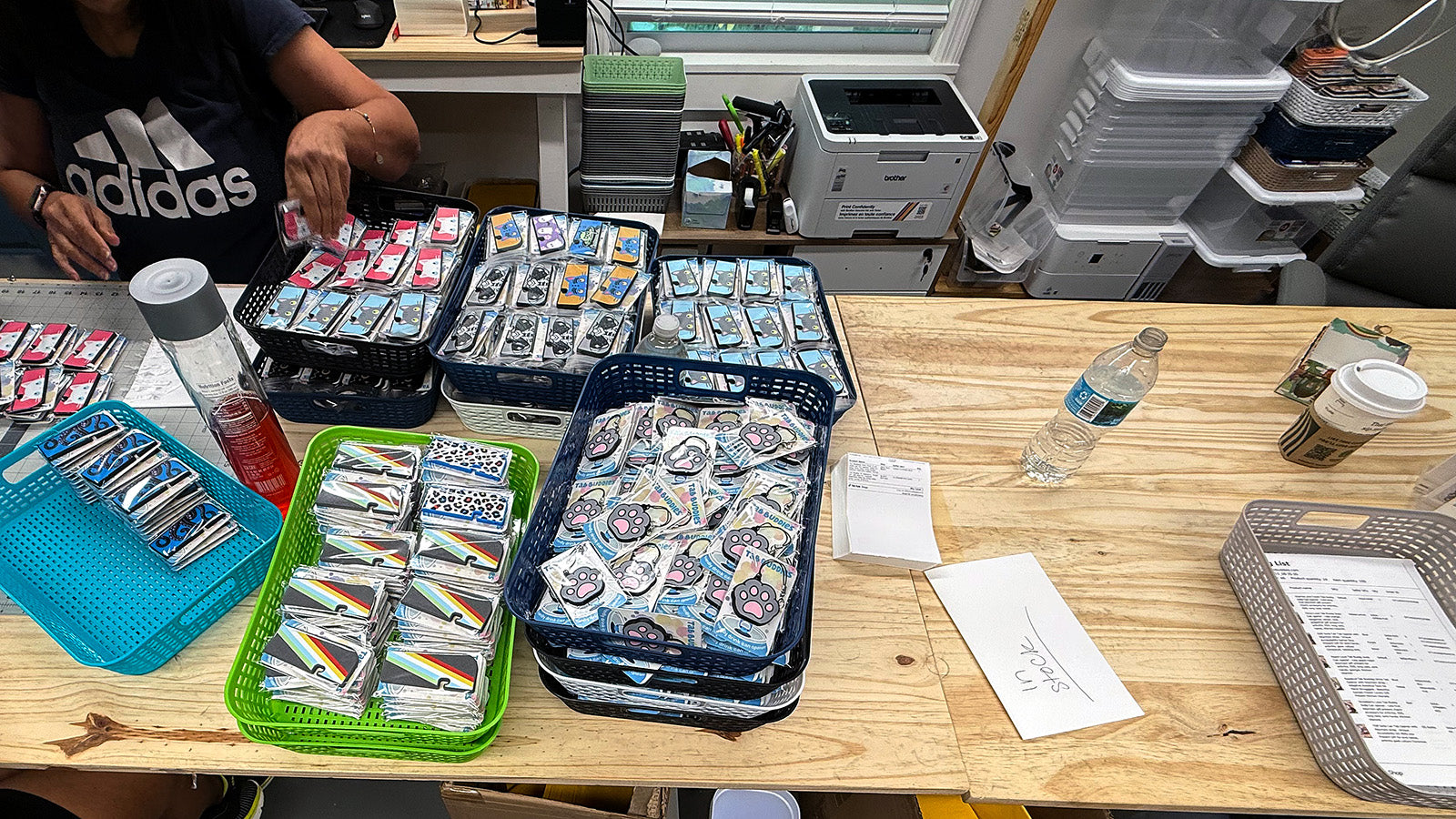 Table with trays of Tab Buddies and office supplies in a casual setting fulfillment workshop