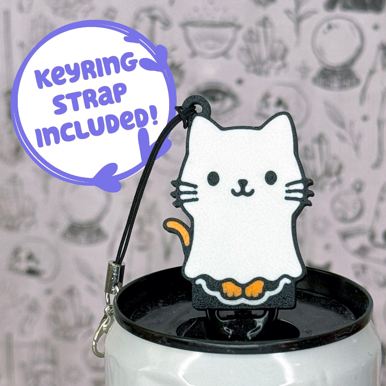 White cat-shaped Tab Buddy keychain with a black strap on a white can against a gray background with cat illustrations.
