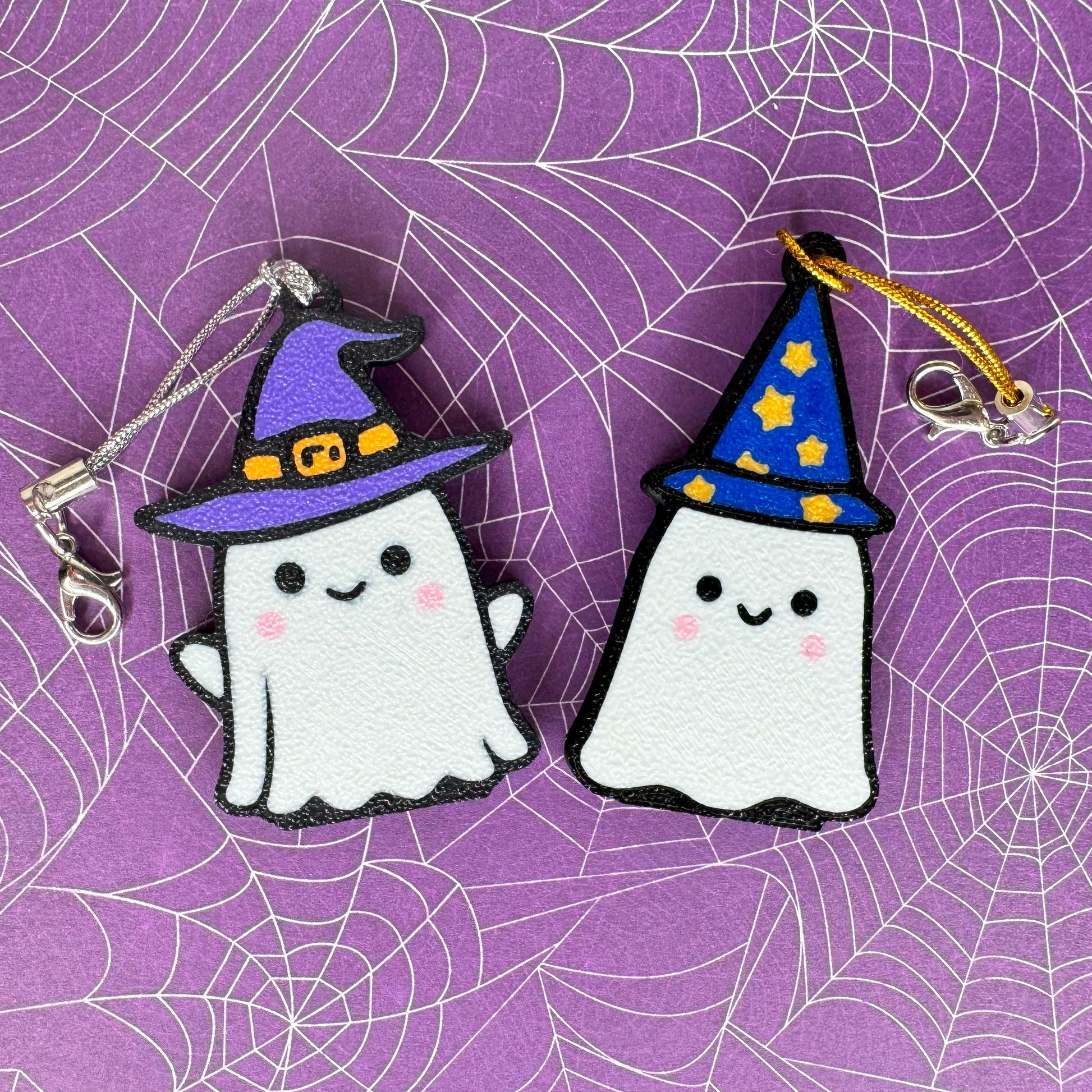 A ghost witch and ghost wizard Tab Buddy on a spider web background