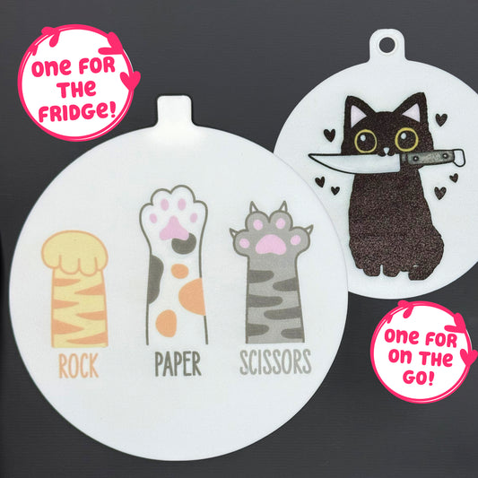 Two circular cat-themed Grippy pads are shown against a grey background. Text bubbles read, "One for the fridge," and "One for on the go!"