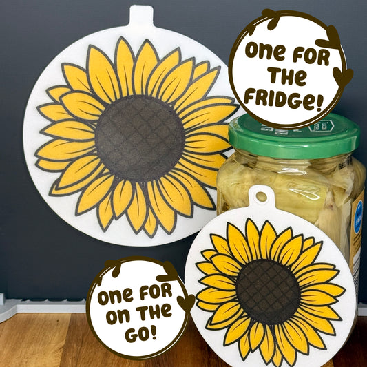 Two silicone Grippy Pads with sunflower designs on a jar and a black surface, with text 'One for the Fridge!' and 'One for On the Go!'.