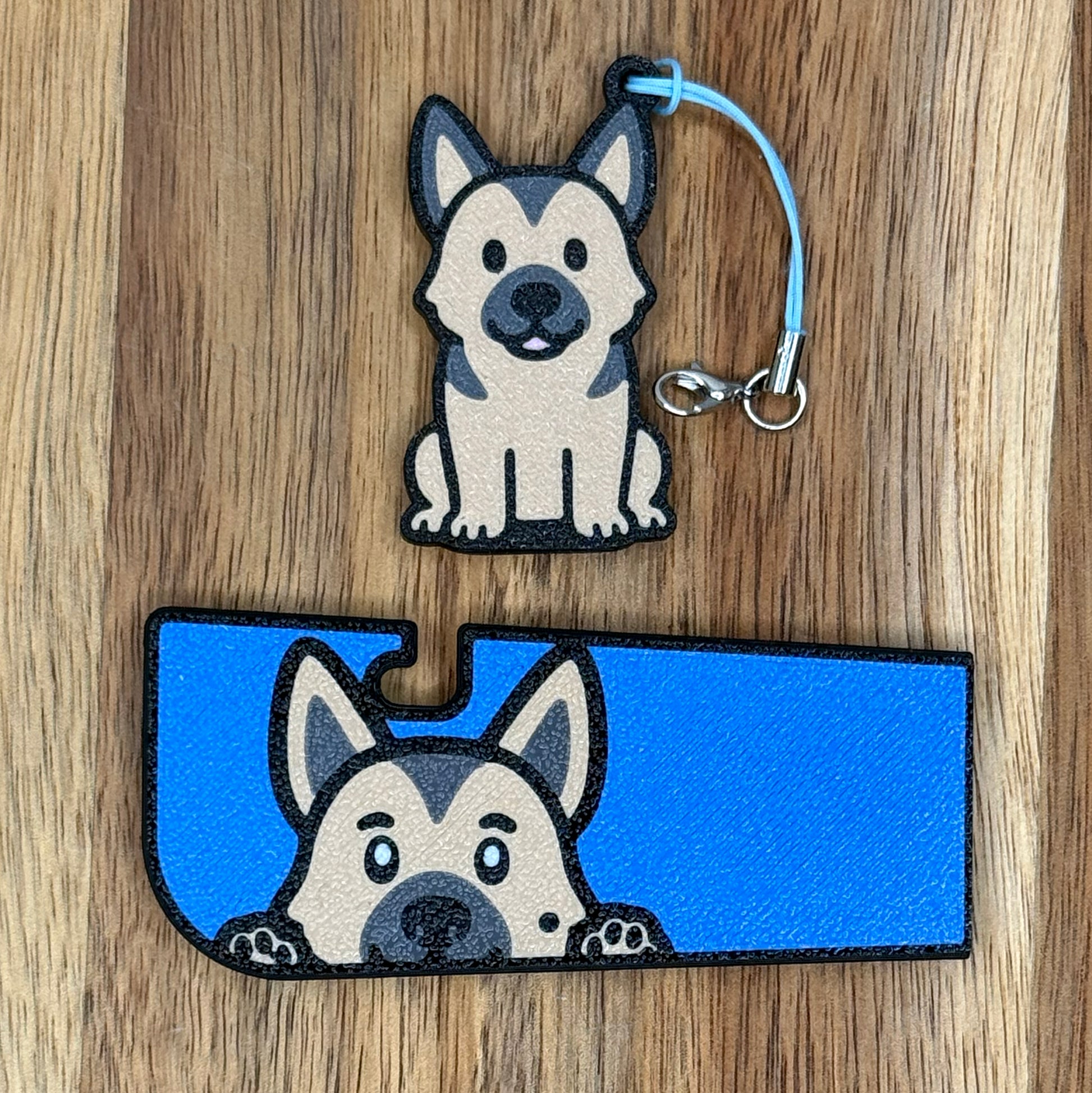 A matching set of German Shepherd-inspired soda Tab Buddy and Tab Buddy XL rest atop a wooden surface.