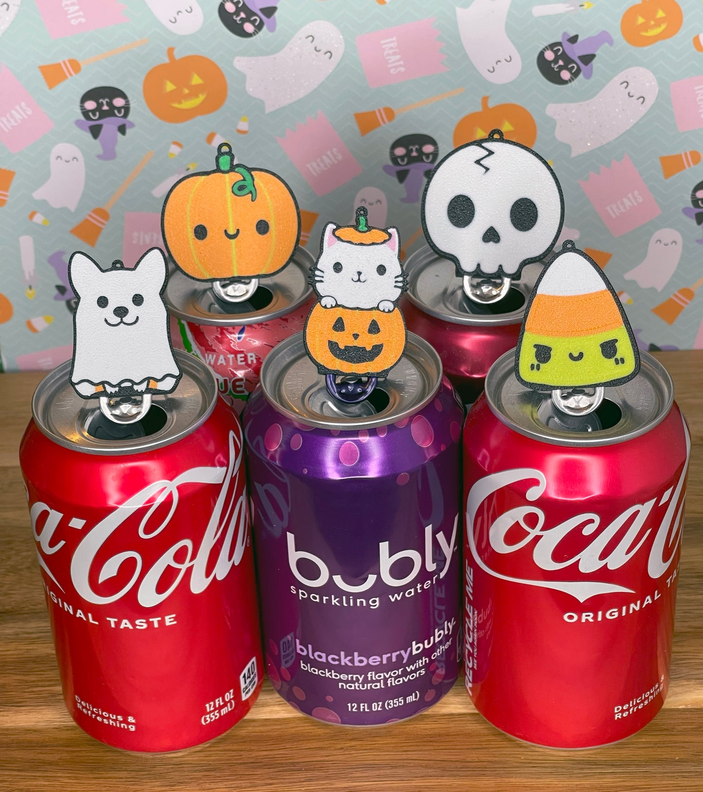 Coca-Cola and bubly sparkling water cans with Halloween-themed Tab Buddies on a colorful background.
