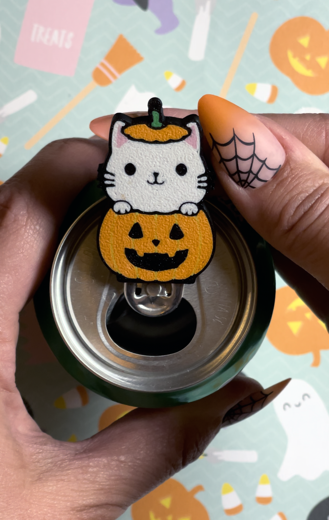 Halloween-themed Tab Buddy with a cat in a pumpkin design held by a hand.