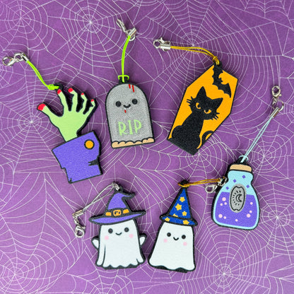 Set of Halloween-themed Tab Buddy keychains on a purple spider web background